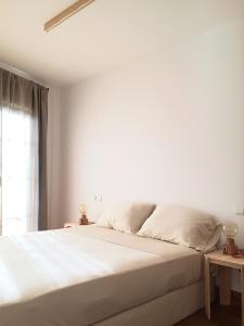 a bedroom with a large white bed with a window at Deltaic :: green ecosystem in Deltebre