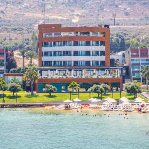 um hotel com uma praia em frente a um edifício em Miramar Hotel Resort and Spa em Trípoli