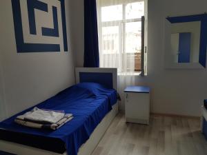 a small bedroom with a blue bed and a window at guest house Telavi XXI in Telavi