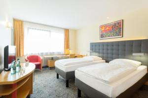 Postel nebo postele na pokoji v ubytování ABACUS Tierpark Hotel