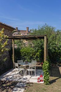 patio con tavolo e sedie sotto un pergolato di Casa Vignolo a Montalcino