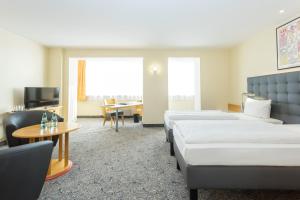 TV a/nebo společenská místnost v ubytování ABACUS Tierpark Hotel