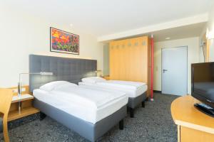 TV a/nebo společenská místnost v ubytování ABACUS Tierpark Hotel
