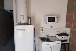 a small kitchen with a refrigerator and a sink at Cabaña en Belén in Belén