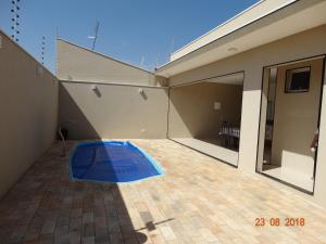 una casa con una piscina azul en medio de un patio en Recanto da Tata, en Olímpia
