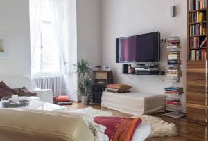 a living room with a couch and a flat screen tv at Spacious old town luxury apartment in Linz