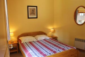 ラ・タニアにあるRésidence Atrey Clés Blanchesのベッドルーム1室(ランプ2つ、鏡付)