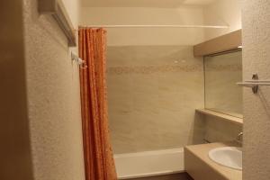 Baño con cortina de ducha naranja junto a un lavabo en Résidence Atrey Clés Blanches en La Tania