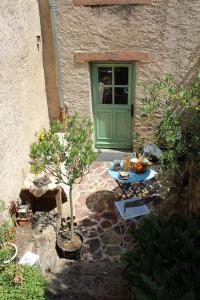 un patio con una mesa y una puerta verde en L'ateliere en Ottrott