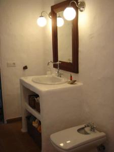 a bathroom with a sink and a toilet and a mirror at Casa Callao in Famara