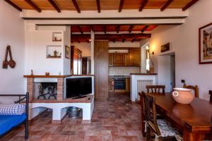 un soggiorno con TV e tavolo da pranzo di Casa Vignolo a Montalcino