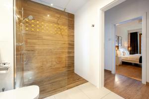 a bathroom with a shower with a wooden wall at Browar Lubicz Residence in Kraków