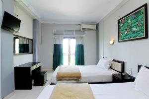 سرير أو أسرّة في غرفة في Hotel Bugis Asri