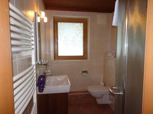 a bathroom with a sink and a toilet and a window at Appartement Kaprun Haus Rudolf in Kaprun
