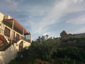 a house on a hill with a mountain in the background at Padmaa Hampi Villa in Hampi