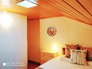 a bedroom with a bed and a clock on the wall at Pure Lisbon Loft里斯本特色阁楼公寓 in Lisbon