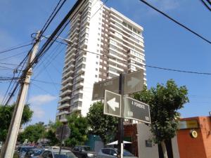 un letrero de la calle frente a un edificio alto en Delpino Propiedades Palmas del Mar, en Viña del Mar