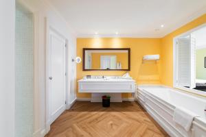 a bathroom with a tub and a sink and a mirror at The Yeatman in Vila Nova de Gaia