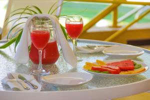 una mesa con dos vasos de zumo y un plato de fruta en Hotel Los Parrales, en Tarija
