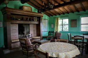 un soggiorno con camino, tavolo e sedie di villa Catola a Bucine