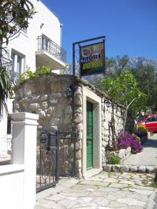 un edificio de piedra con una puerta verde y un cartel en Apartments Villa More, en Makarska