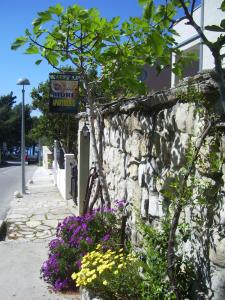 a stone wall with a sign for a flower pharmacy at Apartments Villa More in Makarska
