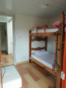 a room with two bunk beds and a mirror at Elizabetha Hostal in Salento
