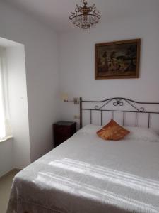 アルデアダビラ・デ・ラ・リベラにあるCasa Rural Mimbreroのベッドルーム1室(白いベッド1台、シャンデリア付)