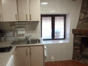 cocina con fregadero y ventana en Casa Rural Los Robles en Valverde de los Arroyos