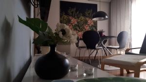 a black vase with flowers on a table in a room at Apartman VEGA in Vukovar