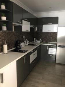 a kitchen with black and white cabinets and appliances at Tardosi Vendégház in Miskolctapolca