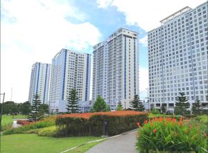 a row of tall buildings in a park with flowers at Home Of Soleil in Tagaytay