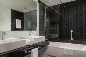 a bathroom with two sinks and a shower at Exe Plaza Catalunya in Barcelona