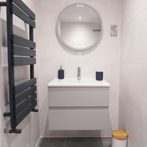 W łazience znajduje się biała umywalka i lustro. w obiekcie Saltwater Suites at Fistral w Newquay