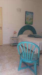 a blue chair sitting in front of a bed at Finestre Sul Mare Salento - CasaVacanza in Punta Prosciutto