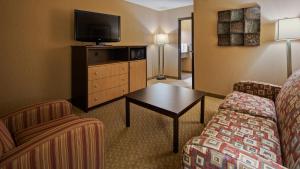 Habitación de hotel con sofá y TV en Crandon Inn & Suites, en Crandon