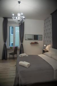 ein Schlafzimmer mit einem großen Bett und einem Kronleuchter in der Unterkunft Inside Roma Rooms in Rom