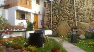 a building with a stone wall and some potted plants at Quinua Boutique Apartments in Cusco
