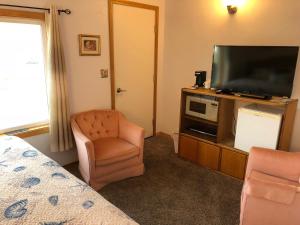 a bedroom with a television and a chair and a bed at Westerly Motel in Ocean Shores