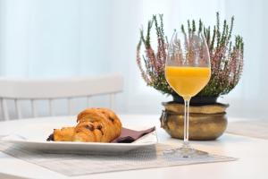 a plate of bread and a glass of orange juice at Studio apartman D&D in Varaždin