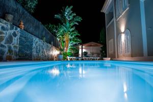 a swimming pool at night with a gazebo at Moradia Correia in Olhão