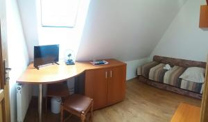 Zimmer mit einem Schreibtisch, einem Computer und einem Bett in der Unterkunft Star in Poprad