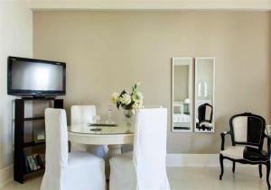a dining room with a table and chairs and a tv at Maritina Apartment in Heraklio