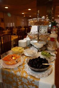 a table topped with bowls and plates of food at Hotel Villa Rosa in Grado