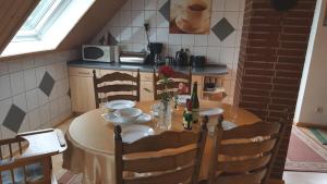 a kitchen with a table and chairs and a kitchen with a table and a table at Ferienwohnung JAGODA in der Lüneburger Heide in Frankenfeld