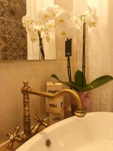 un lavandino con rubinetto e fiori d'oro di Dubrovnik Summer Industry Apartment a Dubrovnik