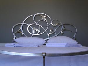 a bed with two pillows and a metal headboard at Villa Marios- Under the Volcano in Zefiría