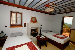 ein Schlafzimmer mit zwei Betten und einem Kamin in der Unterkunft Yono's Traditional House in Áno Ravénia