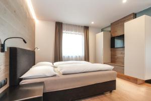 1 dormitorio con 1 cama con 4 almohadas en Gasthof Sonne OHG, en Sarentino