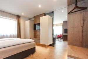 ein Schlafzimmer mit einem Bett und einem Schreibtisch in einem Zimmer in der Unterkunft Gasthof Sonne OHG in Sarntal